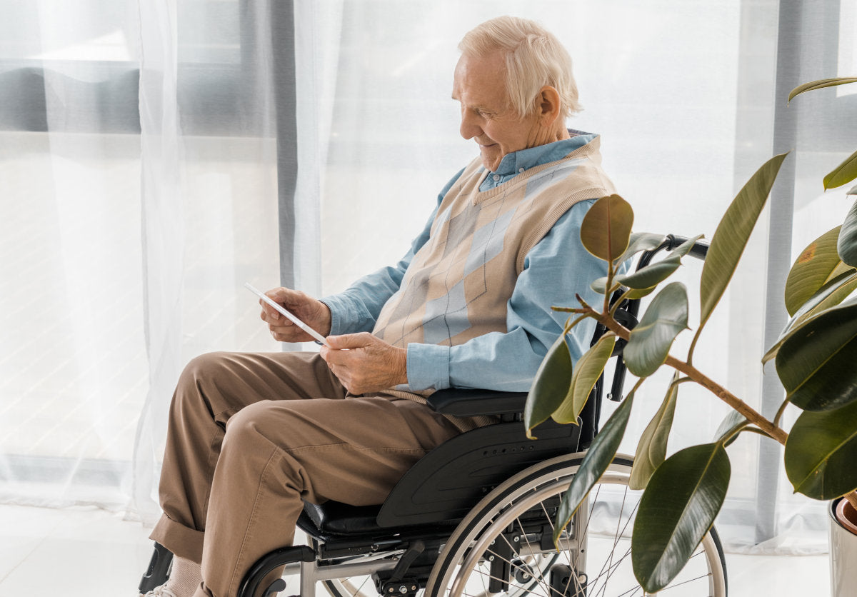 man in wheelchair holding tablet