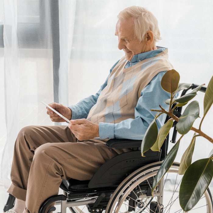 man in wheelchair holding tablet