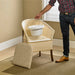 Man lifting bucket from wicker bedroom commode chair