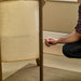 Person assembling or tightening a screw on a wicker chair